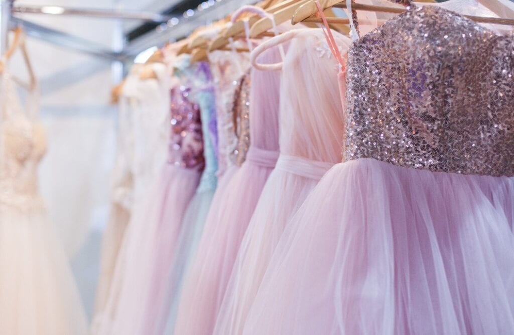 Beautiful elegant evening dresses on hangers in the showroom.
